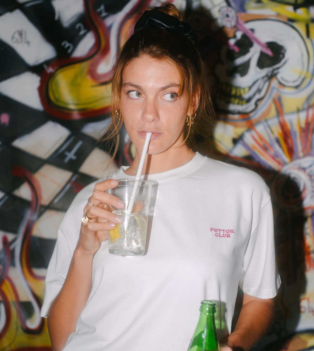 femme qui boit un verre avec un t-shirt pottok club blanc